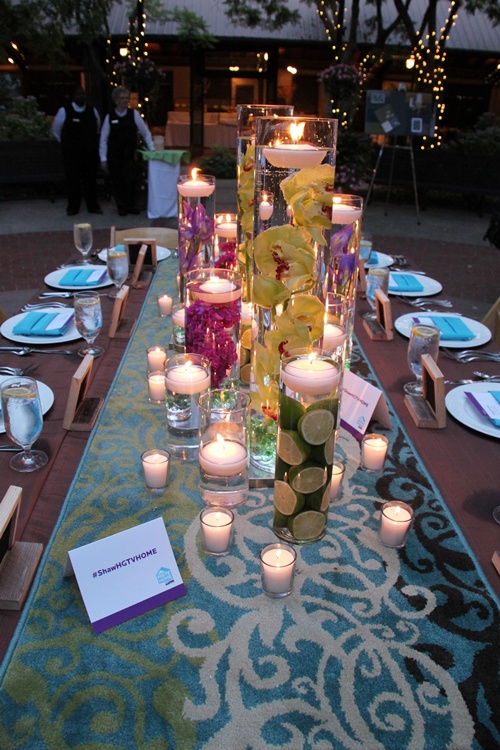 Glass cylinders filled with flowers water and floating candles 