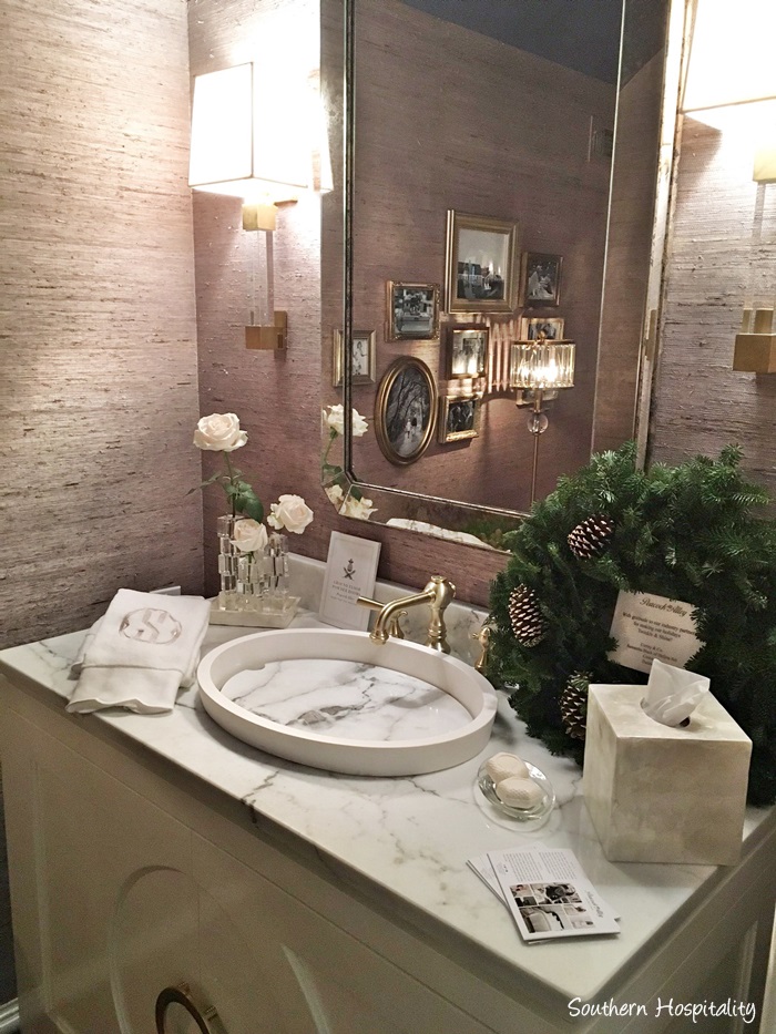 Powder room in Atlanta showhouse 2016 with grasscloth wall covering, marble sink, and gilded frames