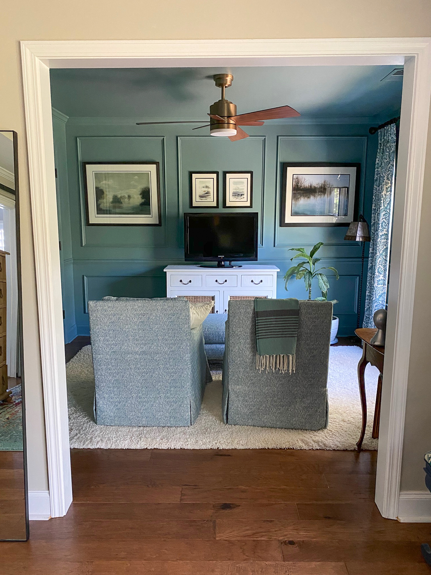 Moody blue sitting room with picture frame molding painted all one color