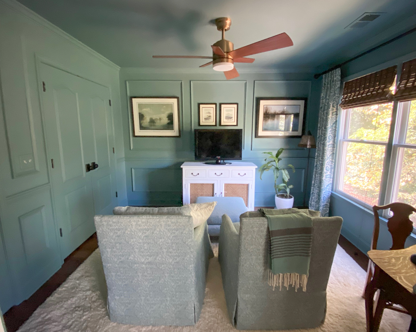 Moody blue sitting room with picture frame molding painted all one color